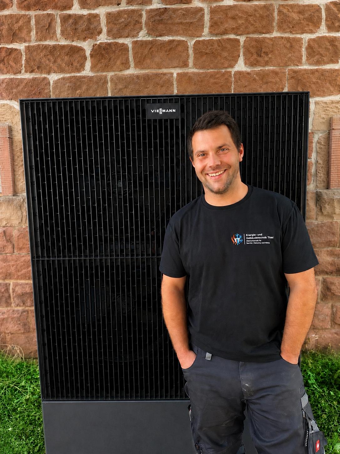 Inhaber der Energie- und Gebäudetechnik Thiel vor einer Viessmann Wärmepumpe